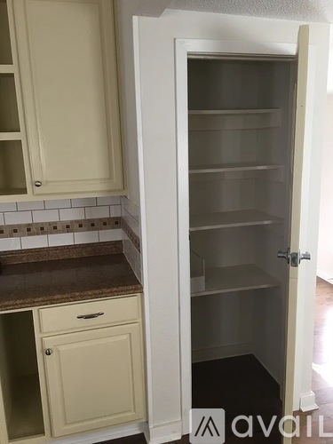 A kitchen with a white cabinet and a white door.