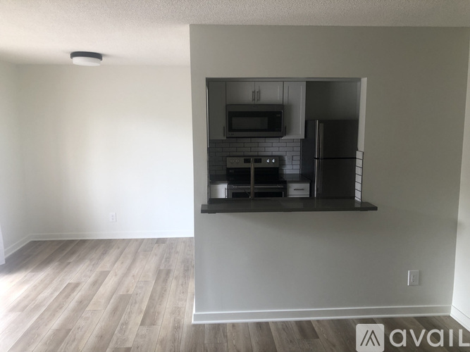A kitchen area with a refrigerator, microwave, and oven.
