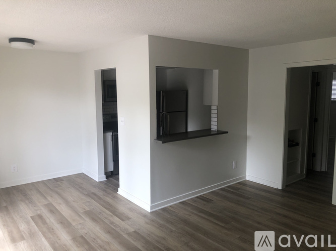 A spacious living room with a flat screen TV mounted on the wall.