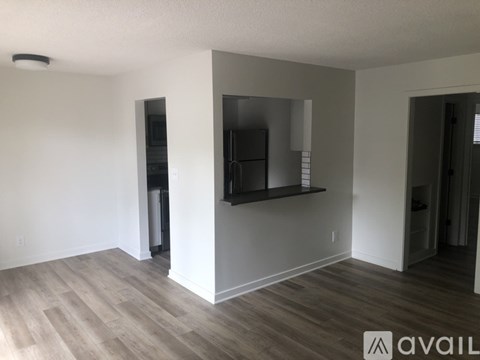 A spacious living room with a flat screen TV mounted on the wall.