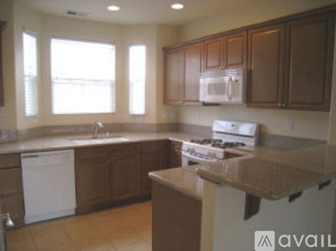 A kitchen with brown cabinets and a white dishwasher.