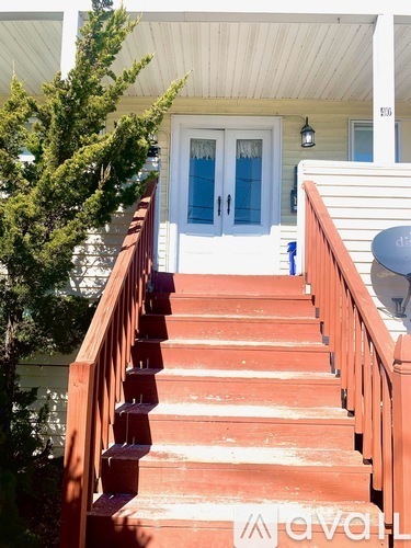 A set of stairs leading to a white door with a glass window.