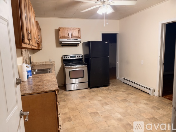 A kitchen with black appliances and wooden cabinets.