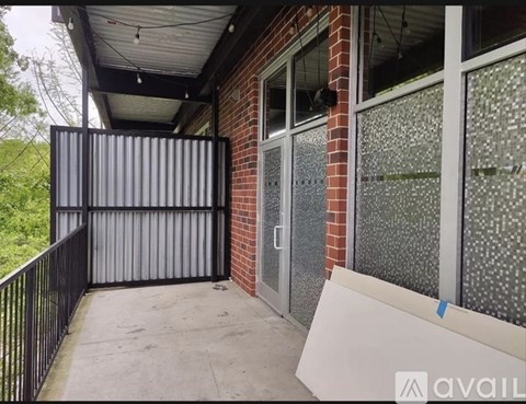 A black gate is closed to a brick building.