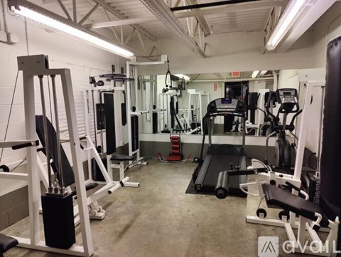 A gym with various exercise machines and weights.