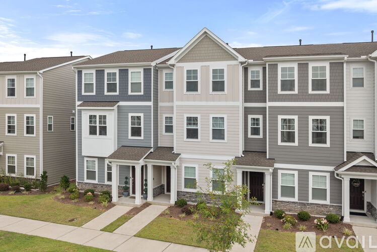 A row of townhouses with a sign that says "available" in front of them.