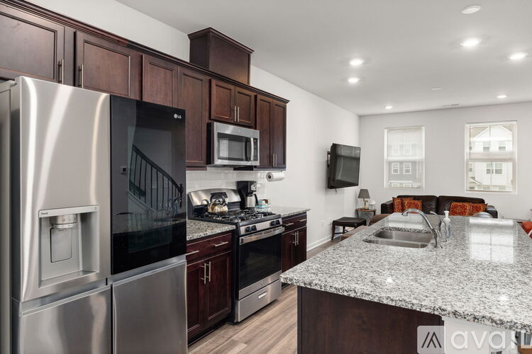 A kitchen with a stainless steel refrigerator and wooden cabinets.