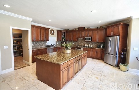 A kitchen with brown cabinets and a granite countertop.