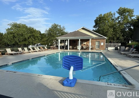 A pool with a blue pool ladder and a poolside house.