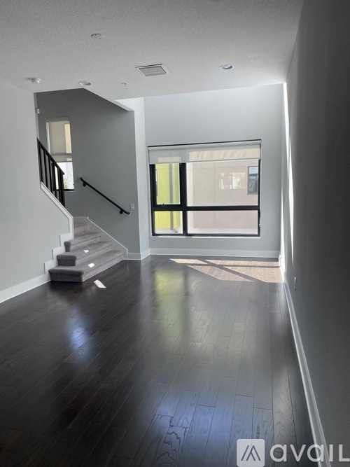 A spacious room with a staircase leading to the upper floor.