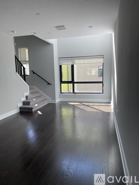 A spacious room with a staircase leading to the upper floor.