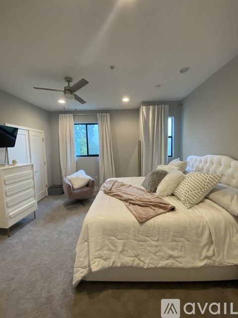 A bedroom with a large bed and a ceiling fan.
