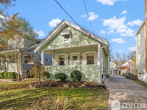 A small house with a green front yard is for sale.