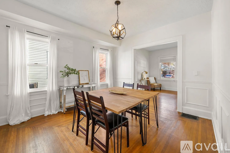 A dining room with a wooden table and chairs.
