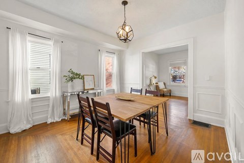 A dining room with a wooden table and chairs.