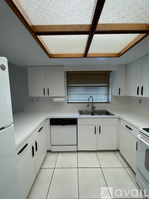 A kitchen with white cabinets and appliances.