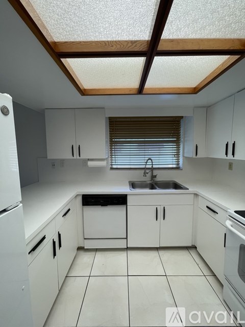 A kitchen with white cabinets and appliances.