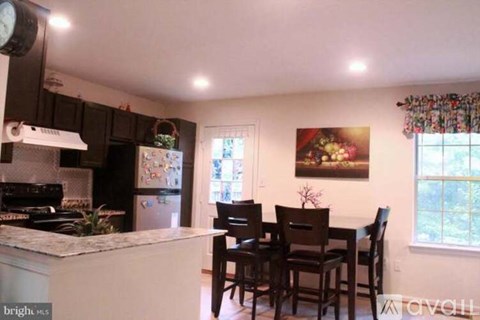 A kitchen with a table and chairs in front of a window.
