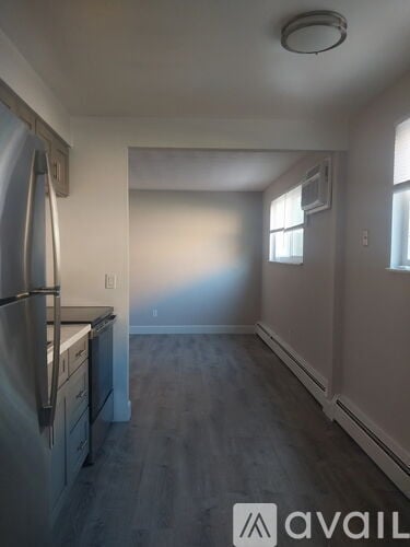A kitchen with a stainless steel refrigerator and wooden floors.