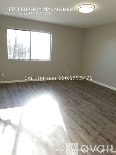 A room with a window showing trees outside and a sign that says "HPM Property Management" and a phone number.