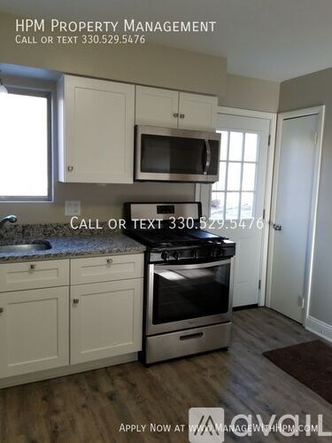 A kitchen with a stove, microwave, and cabinets is for sale.