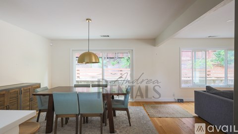 A modern dining room with a glass table and chairs.