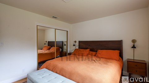 A bedroom with a large bed and a mirror on the wall.