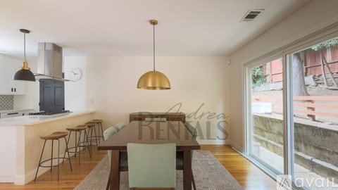 A kitchen with a dining table and chairs in front of a window.