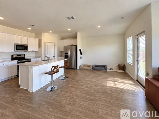 A kitchen with white cabinets and a wooden floor.