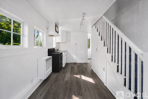 A long hallway with a staircase on the right and a window on the left.