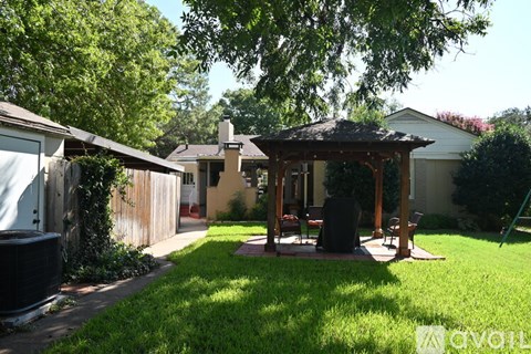 A backyard with a gazebo and a patio table.