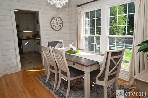 A dining room with a wooden table and chairs.