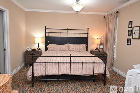 A bedroom with a large bed and a chandelier.