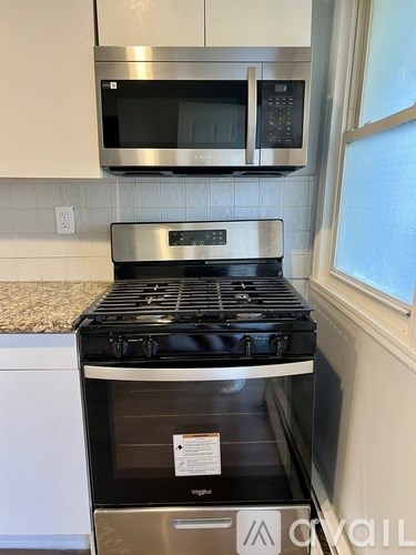 A stainless steel oven with a black glass door is installed in a kitchen.