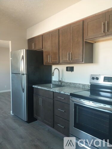 A kitchen with a refrigerator, oven, and sink.
