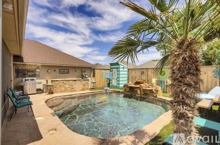 A pool with a palm tree in the foreground.