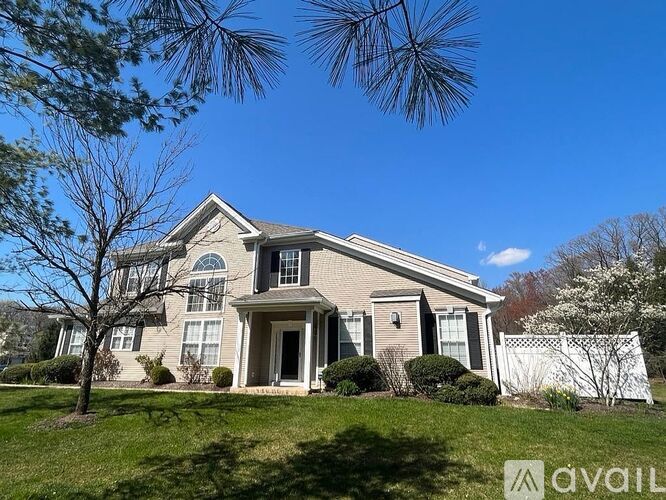 A house with a front yard and a tree.