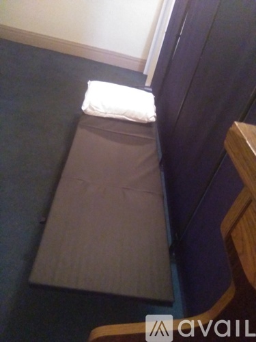 A white pillow is on a grey cushion.