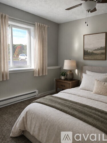 A bedroom with a bed, nightstand, and window with curtains.