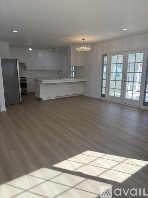 A spacious kitchen with a refrigerator, sink, and a large island.