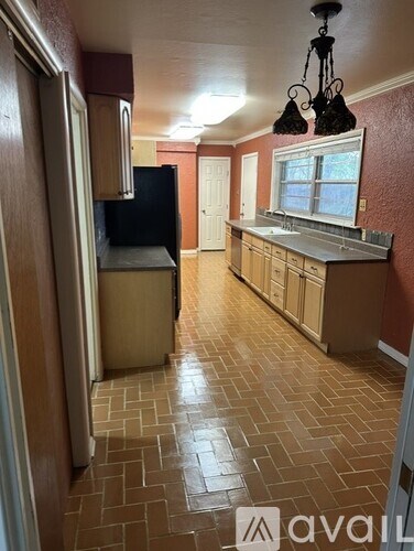A kitchen with a black refrigerator and wooden cabinets.