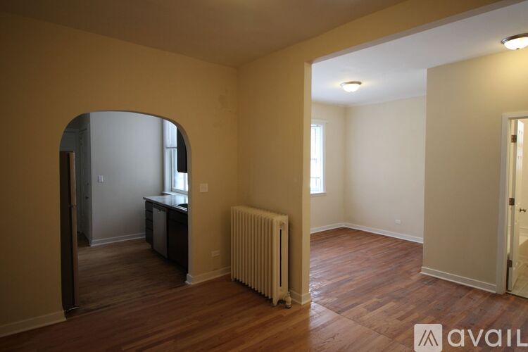 A room with a wooden floor and a white radiator.