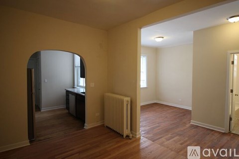 A room with a wooden floor and a white radiator.