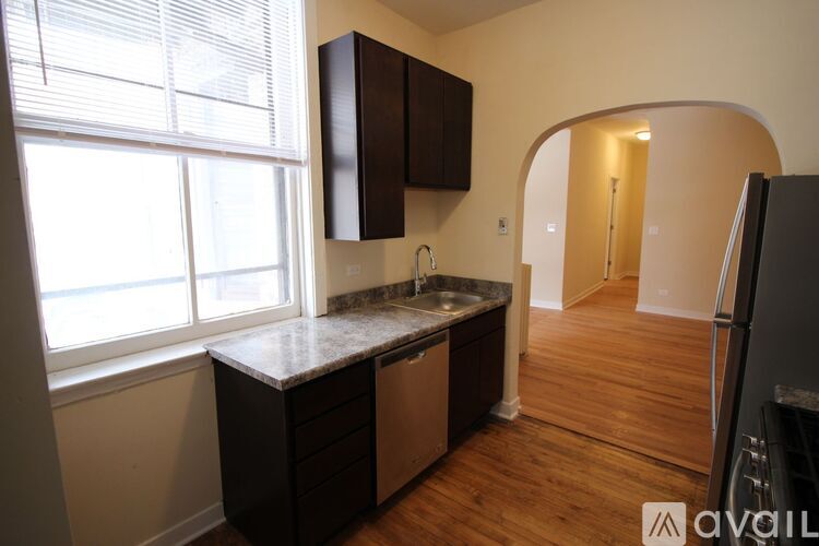 A kitchen with a sink and a refrigerator.
