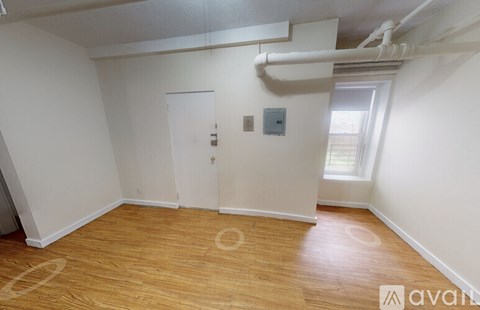A room with wooden flooring and a white door.