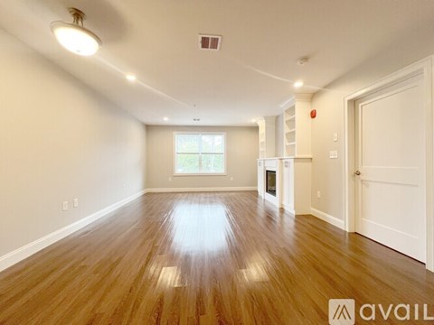 A spacious room with wooden floors and white walls.