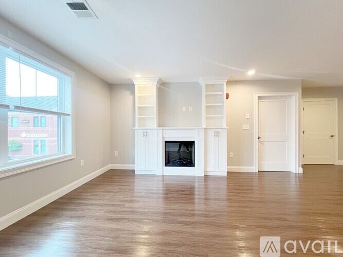 A spacious living room with a fireplace and built-in shelves.
