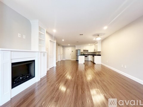 A spacious living room with a fireplace and hardwood floors.