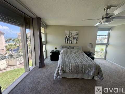 A bedroom with a large bed and a ceiling fan.