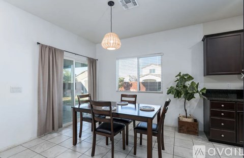 A dining room with a table set for two and a window with blinds.